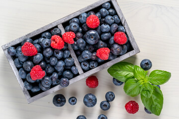 blueberries and raspberries in wooden crates.