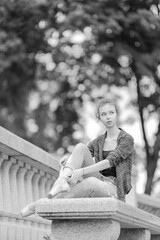 Black and white photo of a ballerina girl in jeans and pointe shoes, dancing and posing in the city on the street © Tatiana