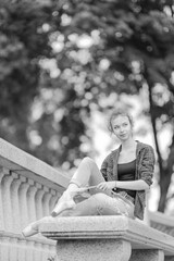 Black and white photo of a ballerina girl in jeans and pointe shoes, dancing and posing in the city on the street © Tatiana