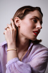 Vertical portrait of young confident female with appealing appearance, wearing lavender shirt.