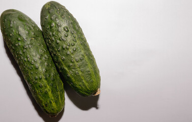 Aerial Shot Of A Group Of Two Fresh Green Cucumbers On White Background