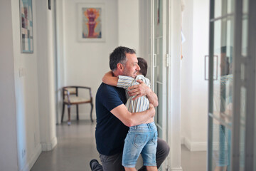 child hugs father at home