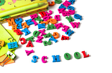multicolored English alphabet letters and school supplieson a white background