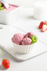 Strawberry ice cream in bowls on white. Close up