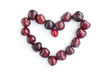 Heart shaped red cherries on a white background. Background from cherries. Sweet cherry isolated on a white background cutout. Hill of ripe cherries isolated on white.