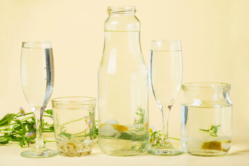 distorted glass of water, flowers distorted by liquid water and glass on yellow