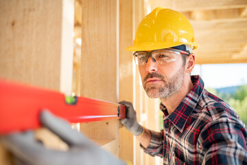 Worker with work tools working on structure of construction at building site
