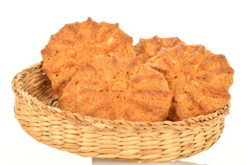 Fragrant tasty, sweet cereal cookies in a straw basket, close-up, on a white background.