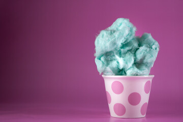 Blue cotton candy in bowl on pink background