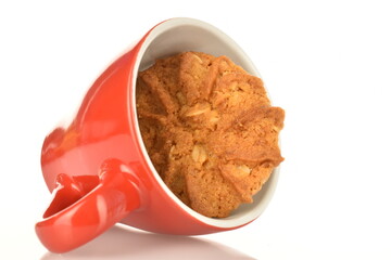 Fragrant tasty, sweet cereal cookies with a ceramic cup, close-up, on a white background.