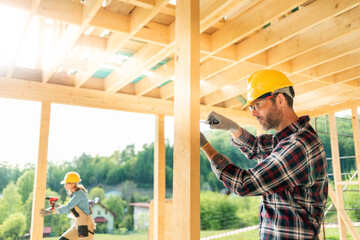 Worker with work tools working on structure of construction at building site