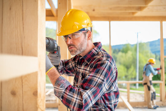 Worker with work tools working on structure of construction at building site