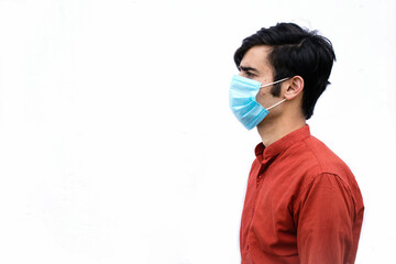 portrait of young teen, depressed. an asian male with mask isolated on a white background with space for text.side view of male.