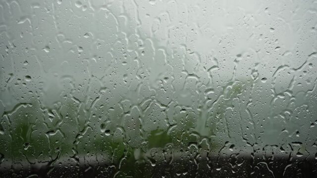 drops of water from the heavy rain splash against the windows of the car