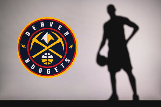 NEW YORK, USA, JUN 18, 2020: Denver Nuggets logo of professional basketball club in american league. Silhouette of basket player in foreground. Sport concept photo, edit space.