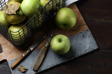 Garden green apples in a metal basket on the table