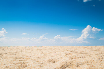 Fototapeta na wymiar View of empty tropical sand beach with puffy white cloud and blue sky background