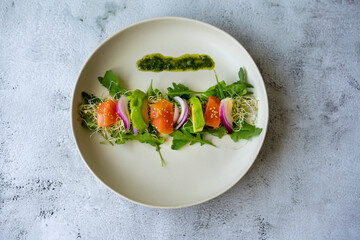 avocado, smoked salmon and cucumber salad on white plate