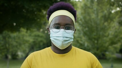 A portrait of a confident black woman. An essential worker wearing a mask. Slow-motion and shot in 4k. - Powered by Adobe