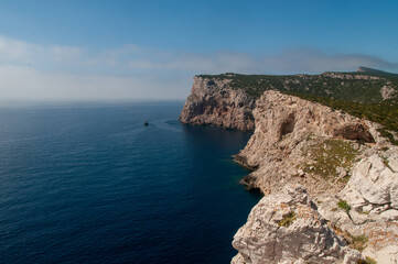 Fototapeta na wymiar White cliff on Capo Caccia coastline with blue sea. Sardinia, Italy