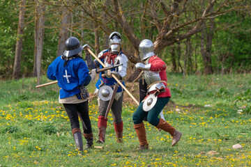 Knights in armor fight on the battlefield. Reconstruction of an ancient battle of the 15th century.