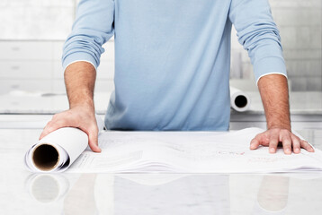 Cropped photo of architect holding plans in office