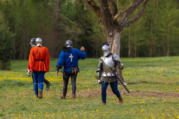 Knights in armor fight on the battlefield. Reconstruction of an ancient tournament of the 15th...