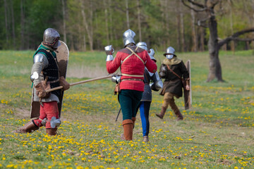 Knights in armor fight on the battlefield. Reconstruction of an ancient tournament of the 15th...