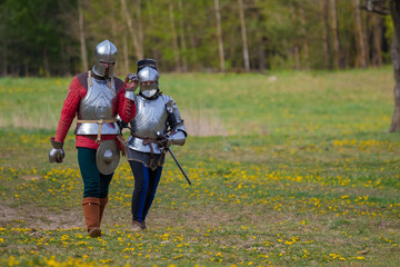 Knights in armor fight on the battlefield. Reconstruction of an ancient battle of the 15th century.