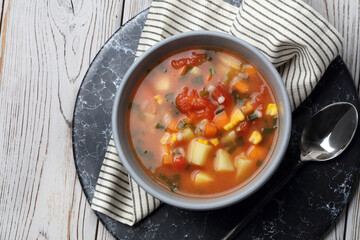 Tomato soup with potatoes, carrots, corn, barley and green onions