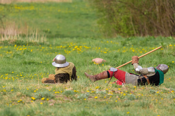 Knights in armor fight on the battlefield. Reconstruction of an ancient tournament of the 15th...