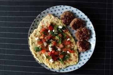 Greek grill meatball on pita with tomato and cucumbers