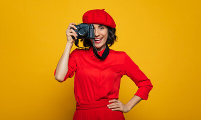 I'm making a photo! Half-length photo of a cute woman on her vacation, french style dressed, carrying a camera on a strap on her neck, with an open mouse, ready to make a photo.
