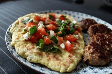 Greek grill meatball on pita with tomato and cucumbers