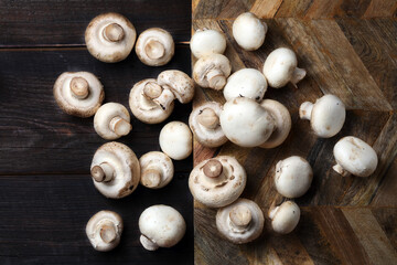 Raw white champignons on a wooden board