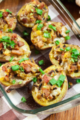 Baked potatoes in jacket stuffed with bacon, mushrooms and cheese. Dish served in baking dish..Baked potatoes stuffed with bacon, mushrooms and cheese