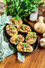 Baked potatoes in jacket stuffed with bacon, mushrooms and cheese. Dish served in baking dish..Baked potatoes stuffed with bacon, mushrooms and cheese