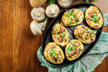 Baked potatoes in jacket stuffed with bacon, mushrooms and chees