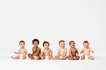 Row of six multi ethnic Babies smiling in studio - obrazy, fototapety, plakaty