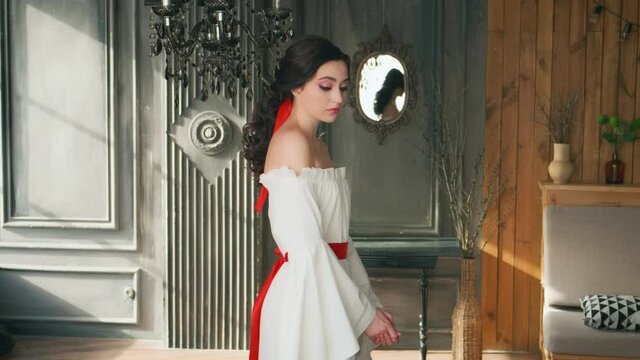Portrait sad young fairytale woman Snow White. Brunette wavy hair collected red ribbon. White sexy vintage boho dress. Backdrop gothic style room medieval castle, in mirror image princess, evil ghost