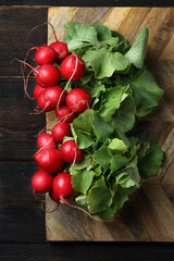 Fresh bunches of red radish on a dark board
