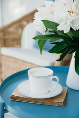 Milk in a cup close-up. Breakfast on terrace. Flower arrangement. Relax.