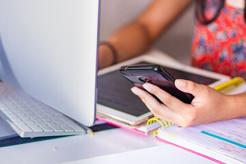 Unrecognizable woman studies with a  smartphone at home 