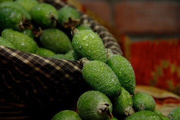 Green feijoa fruits with water sprinkles on them