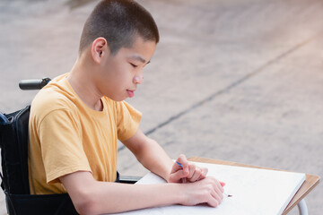 Asian Special need child on wheelchair enjoying training of hand and finger muscles through drawing us paintbrush, Special children's lifestyle and education age, Happy disabled kid concept.