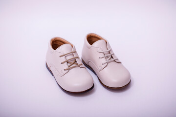 Small child white leather shoes isolated on white background.