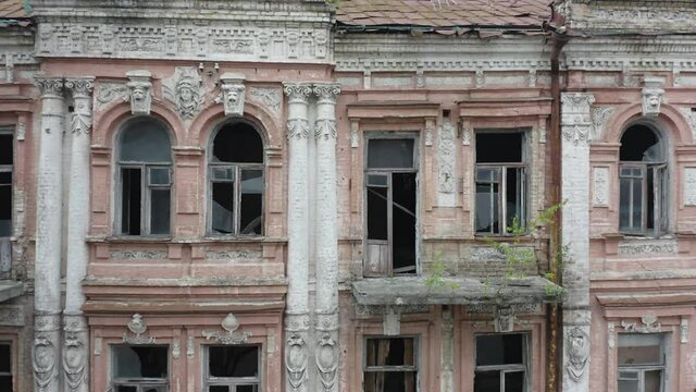 Abandoned old manor (mansion) house in the neoclassical style with an abundance of decor and broken windows. Deserted building of the 19th century. Aerial side view