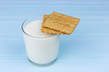 glass of milk with cookies on a blue background, copy spaсe