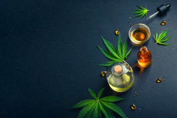 Medical CBD oil, tincture on black trendy background with cannabis leaves
