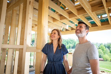 Couple make their dreams of building their own home come true visiting house under construction - obrazy, fototapety, plakaty